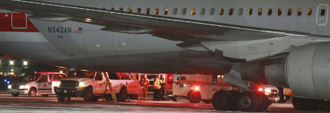 An American Airlines plane that was headed to Milan from Miami sits at the airport in St. John's, Newfoundland, after making an emergency landing Sunday, Jan. 24, 2016. The plane had briefly encountered severed turbulence. American Airlines spokesman Ross Feinstein said three flight attendants and four passengers were transported to hospital for further evaluation. He said he didn't think any of the injuries were life threatening. (Paul Daly/The Canadian Press via AP)